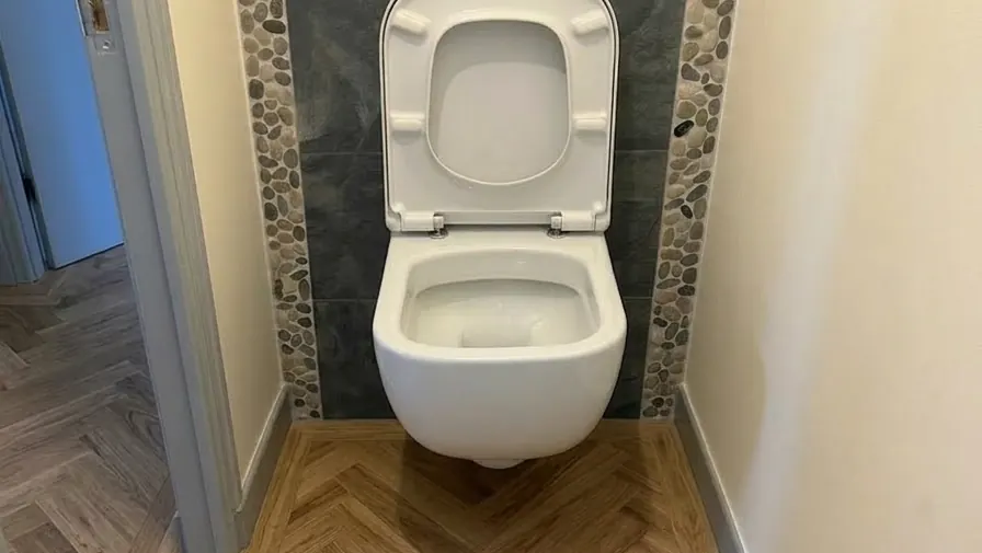 WC suspendu avec habillage faïence galets et parquet chevron