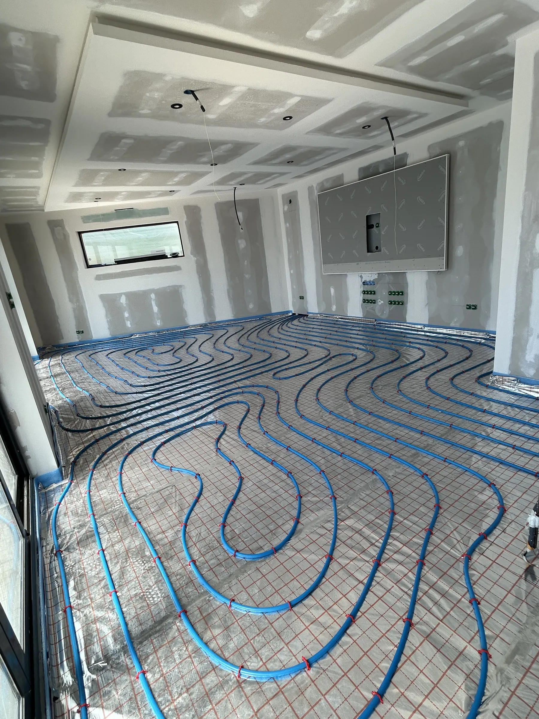 Plancher chauffant hydraulique posé dans une pièce de vie en rénovation