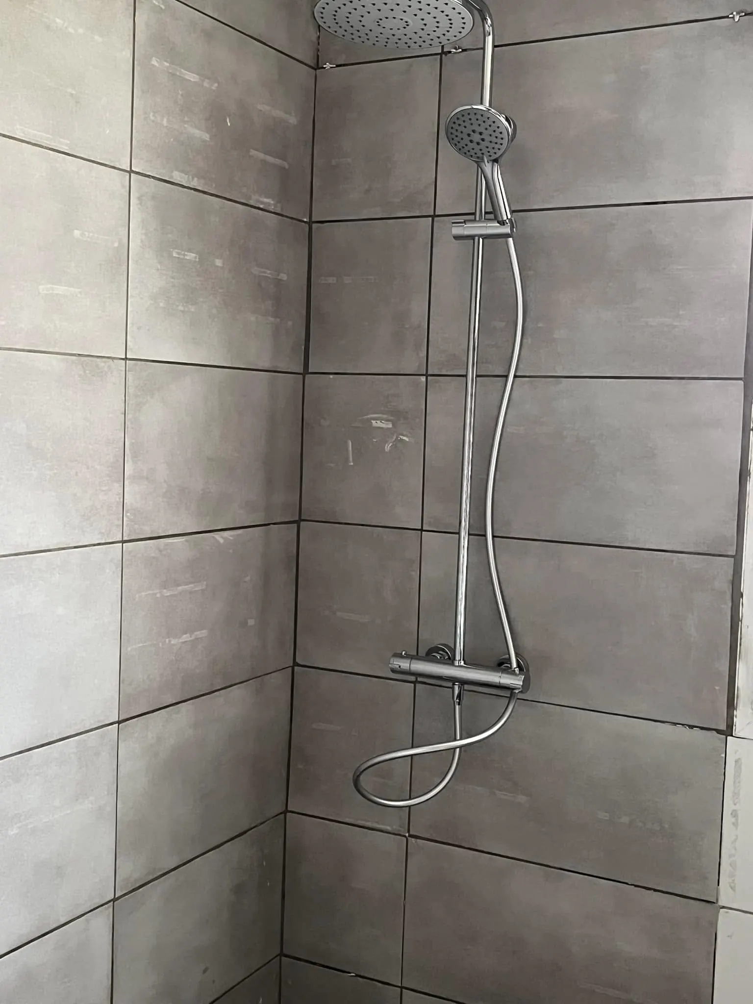 Douche carrelée avec colonne de douche thermostatique et ciel de pluie
